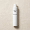 Comfort Zone Essential Persian Water bottle, a tall white cylindrical plastic bottle with a white cap, standing vertically on a textured beige linen background.
