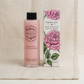 A bottle of French Girl Rose Hibiscus Gentle Wash next to its illustrated packaging box, set against a neutral linen background.
